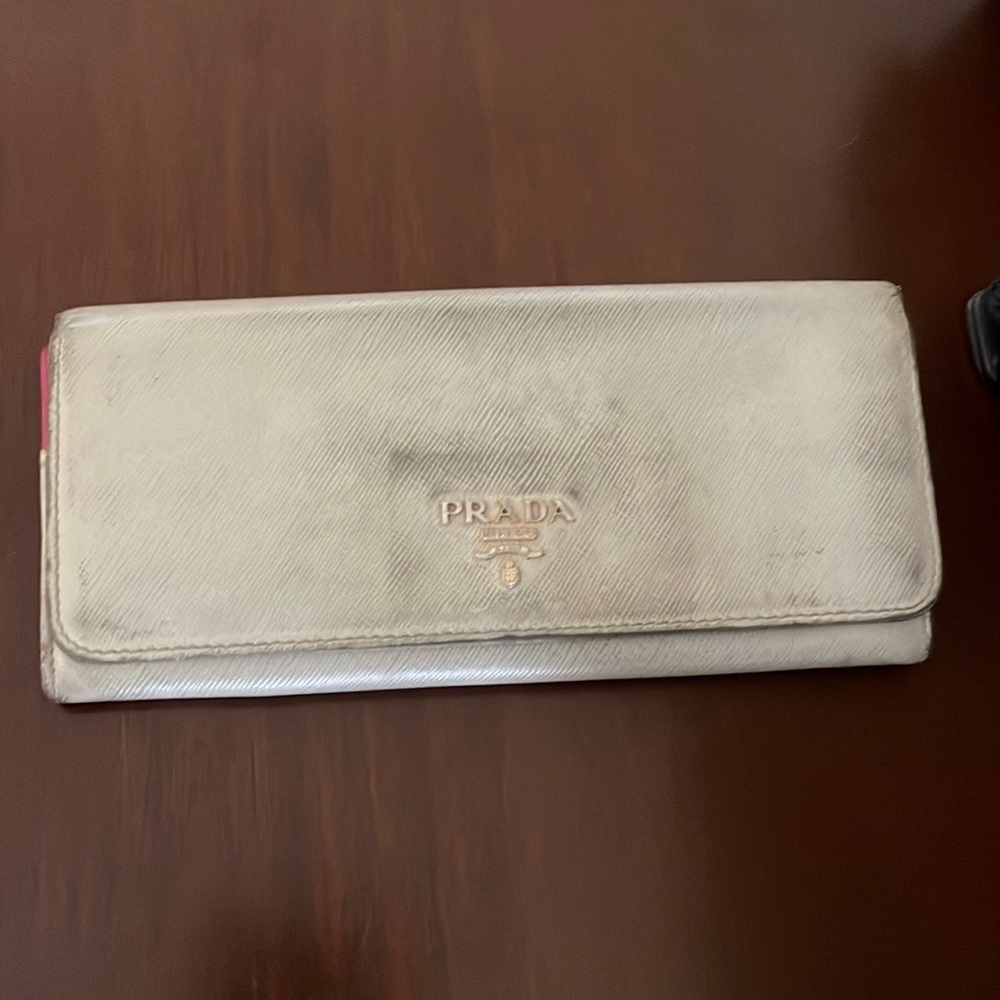 Cream colored Prada wallet.  In used condition.